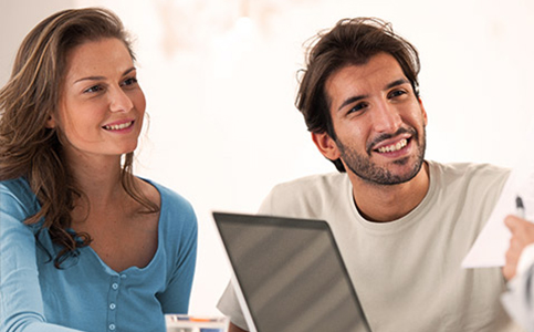 Imagem 5 serviços Consultoria Fotografia de um casal sorrindo e conversando com um gerente enquanto ele segura alguns papéis na mão.