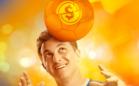 Use a cabeça e tenha crédito para facilitar seu dia a dia Fotografia de Luciano Huck dando cabeçada em uma bola de futebol laranja com o desenho de um cifrão amarelo. Use a cabeça e tenha crédito para facilitar o seu dia a dia.