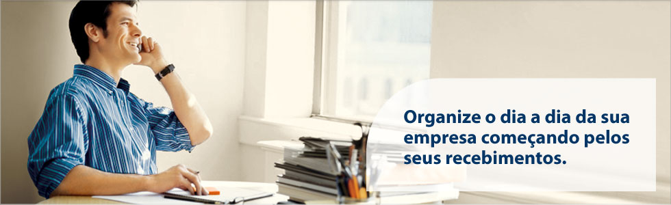 Fotografia de um homem falando no telefone em um escritório onde se encontra uma mesa cheia de livros, papéis e canetas. Ao lado a frase: Organize o dia a dia da sua empresa começando pelas seus recebimentos.