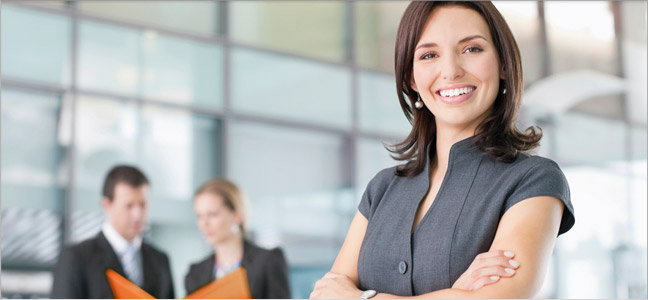 Poder Publico - Investimentos - Imagem 648x300 Fotografia de uma mulher com os braços cruzados e sorrindo.